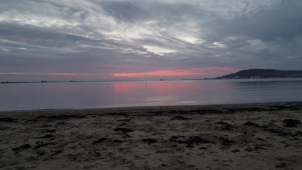Pink hue to the grey day Castle Cove Weymouth